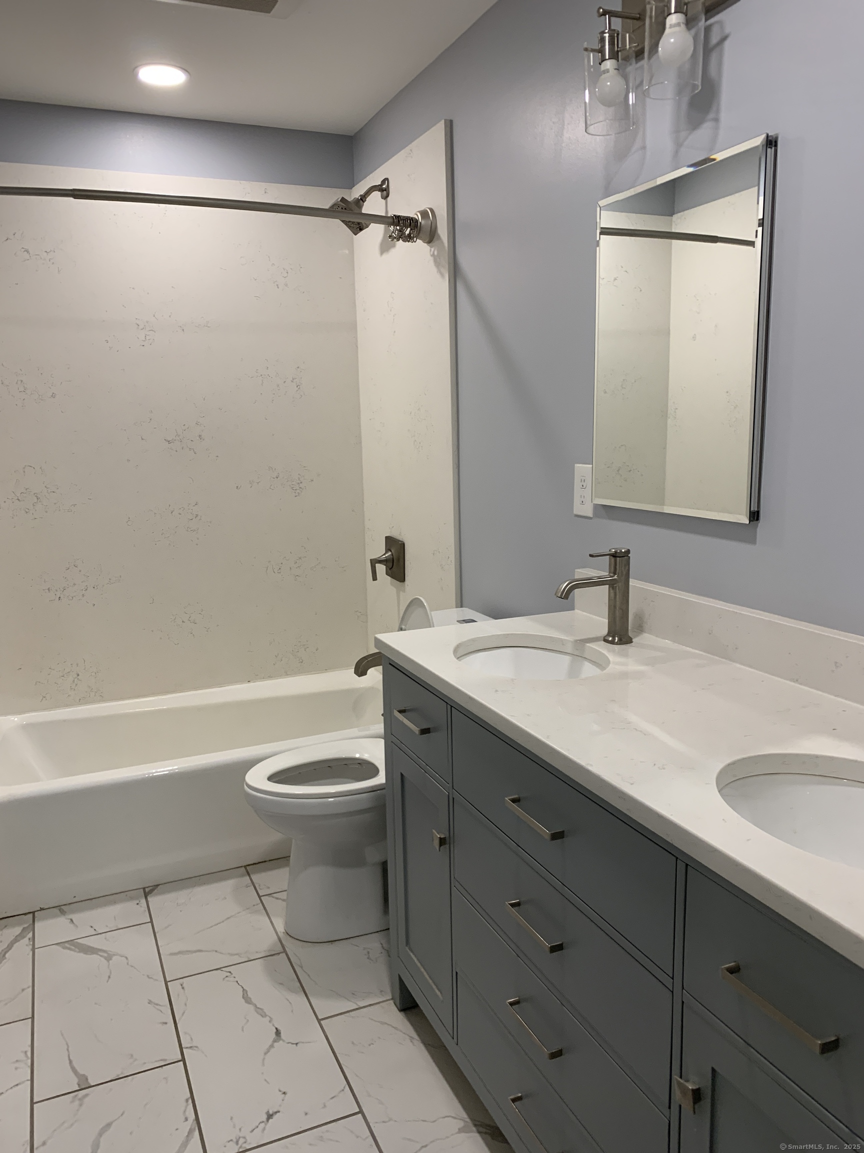 66 Cedar Street, Unit 2 Norwalk, CT 06854 - Photo 11 of 23 a bathroom with a double vanity sink toilet mirror and shower