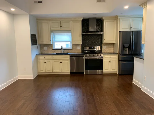 a kitchen with stainless steel appliances granite countertop a refrigerator stove and sink