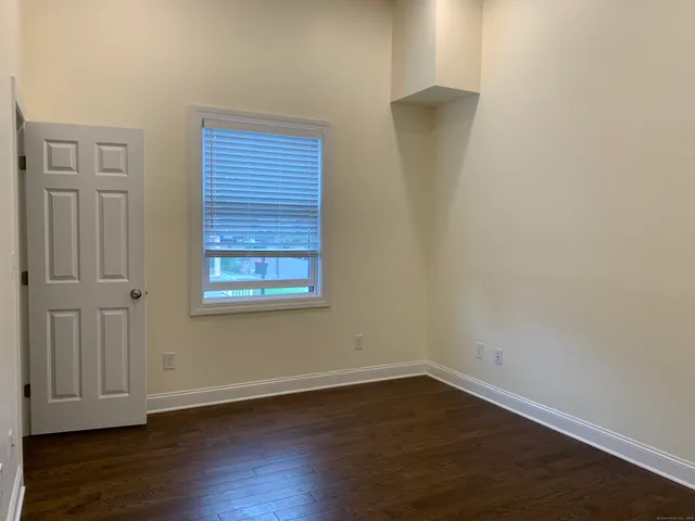 an empty room with wooden floor and closet