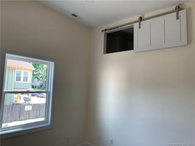 a view of a livingroom with an empty space and a window