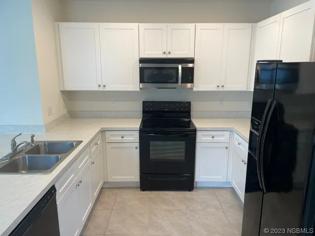a kitchen with a refrigerator and a sink