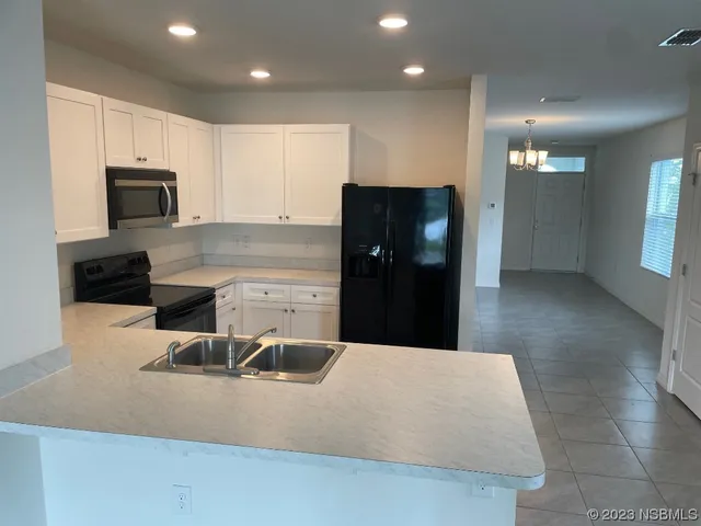 a kitchen with stainless steel appliances a refrigerator sink and microwave