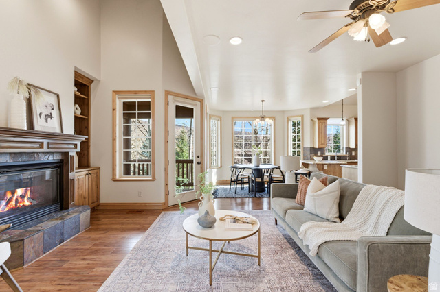 3026 Lower Saddleback Road Park City, UT 84098 - Photo 3 of 71 Living room with light wood-style floors, built in shelves, a tile fireplace, a ceiling fan, and a chandelier