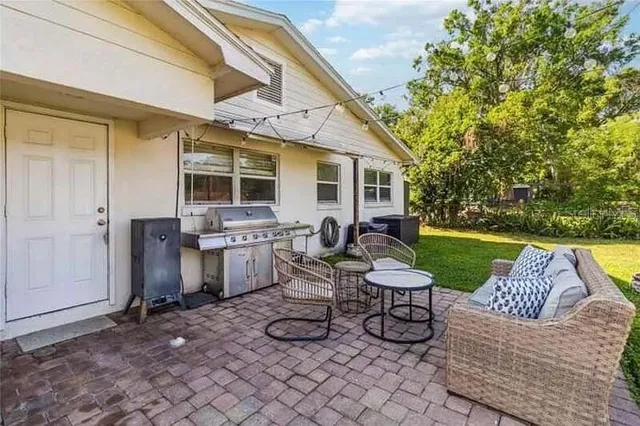 a view of a patio with couches table and chairs and potted plants