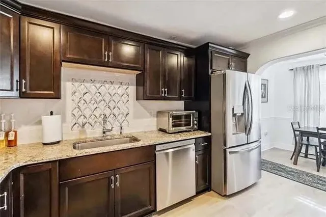 a kitchen with stainless steel appliances a refrigerator sink and cabinets