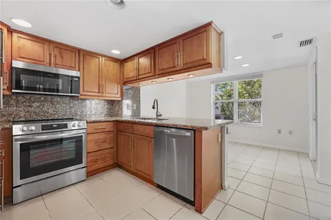 a kitchen with stainless steel appliances granite countertop a stove a microwave and a sink