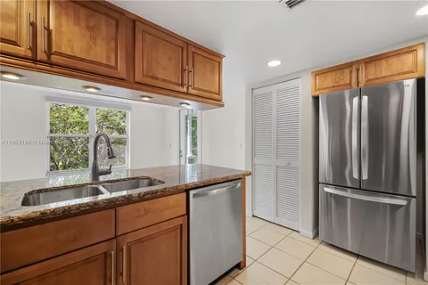 a kitchen with stainless steel appliances granite countertop a refrigerator and a sink