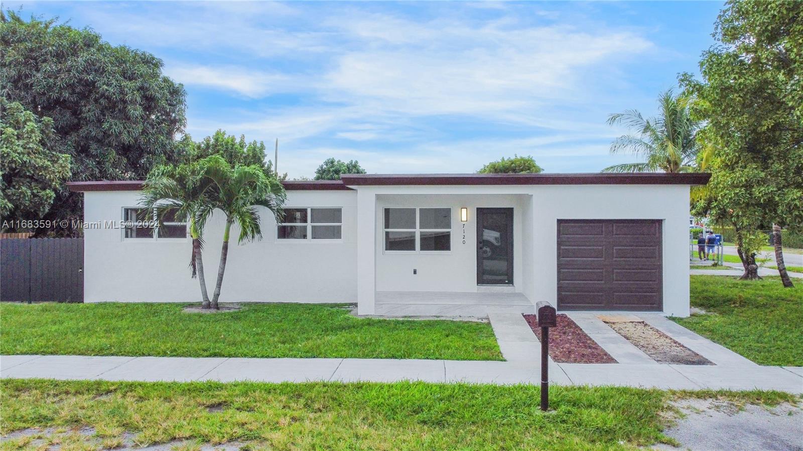 7120 Southwest 9th Street Miami, FL 33144 - Photo 4 of 25 a front view of a house with a garden and yard