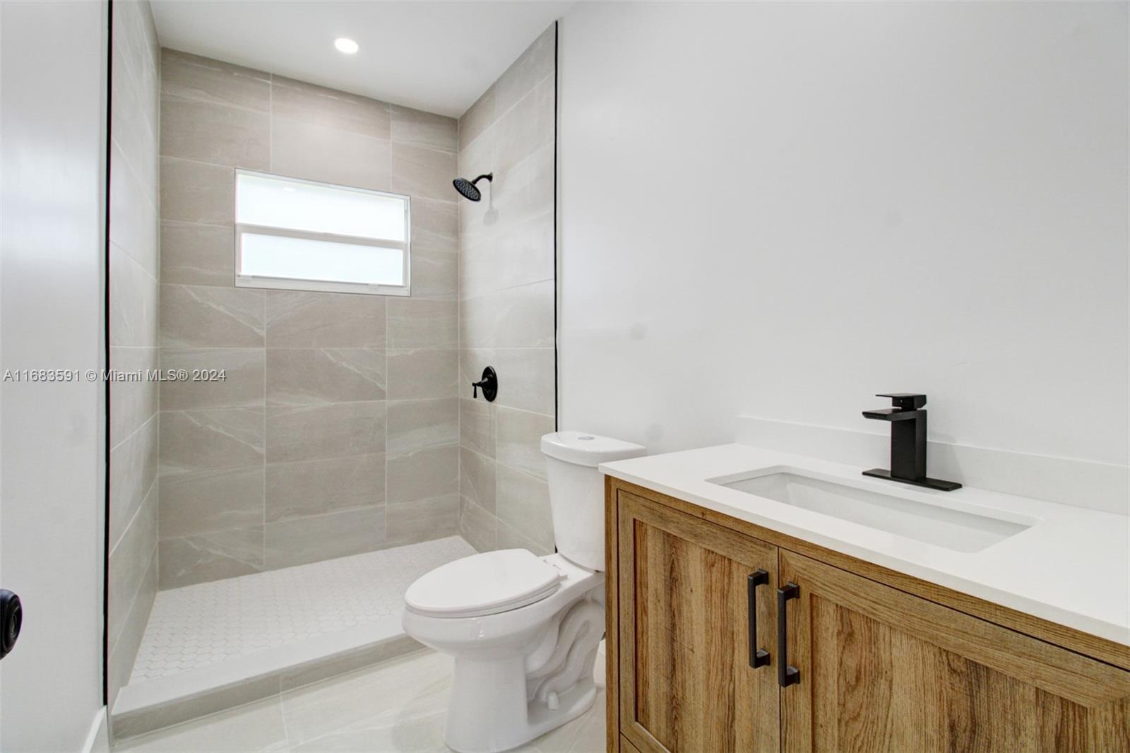 7120 Southwest 9th Street Miami, FL 33144 - Photo 10 of 25 a bathroom with a granite countertop sink a toilet and shower