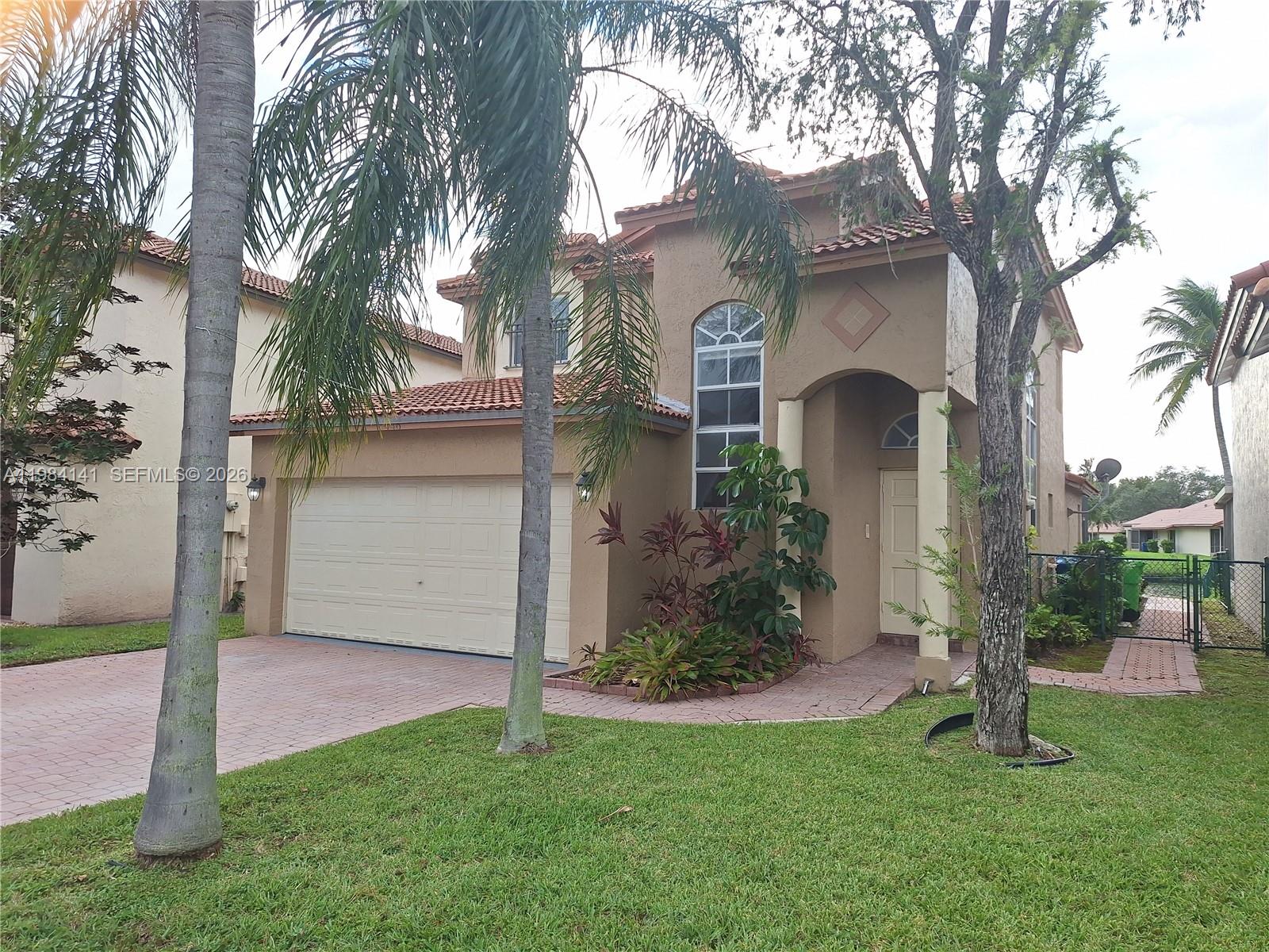 446 Lakeside Circle Sunrise, FL 33326 - Photo 1 of 13 a front view of a house with garden