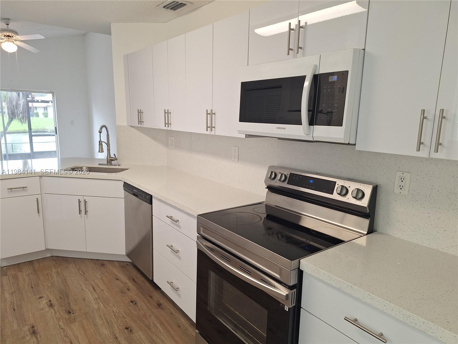 446 Lakeside Circle Sunrise, FL 33326 - Photo 5 of 13 a kitchen with a sink stove and microwave