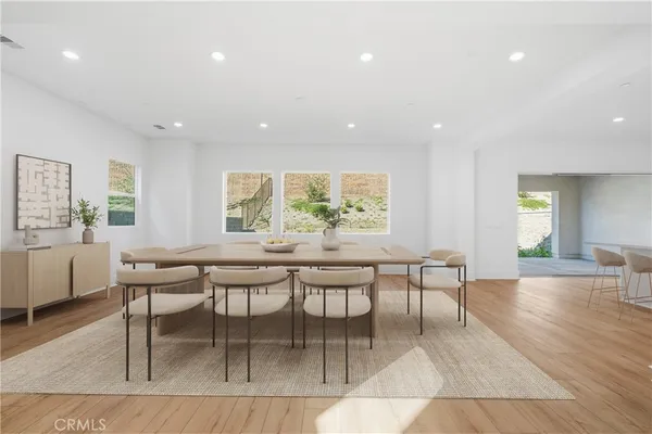 a dining room with wooden floor and window