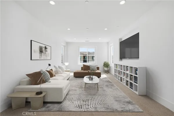a living room with furniture a flat screen tv and a window