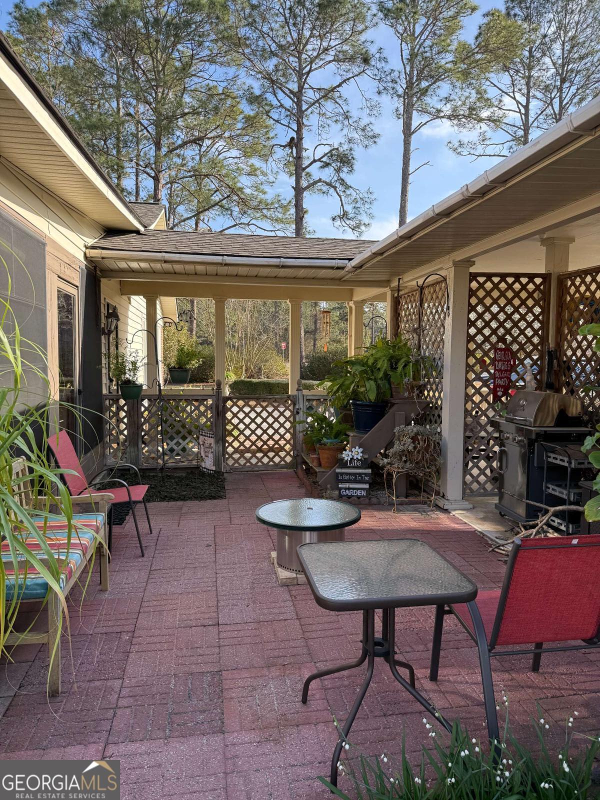 5686 Golden Isle West Baxley, GA 31513 - Photo 120 of 122 a view of a patio with table and chairs potted plants and floor to ceiling window