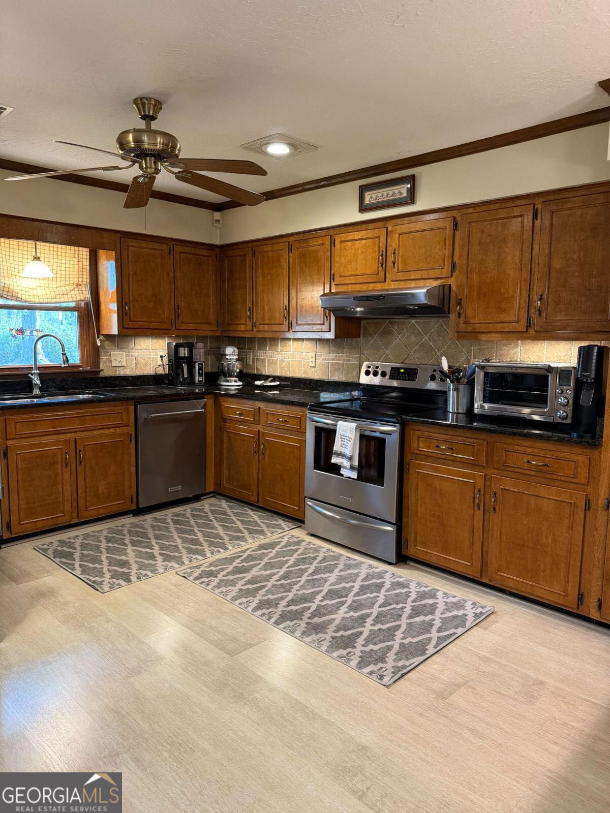 5686 Golden Isle West Baxley, GA 31513 - Photo 44 of 122 a kitchen with stainless steel appliances granite countertop a sink cabinets and a stove top oven