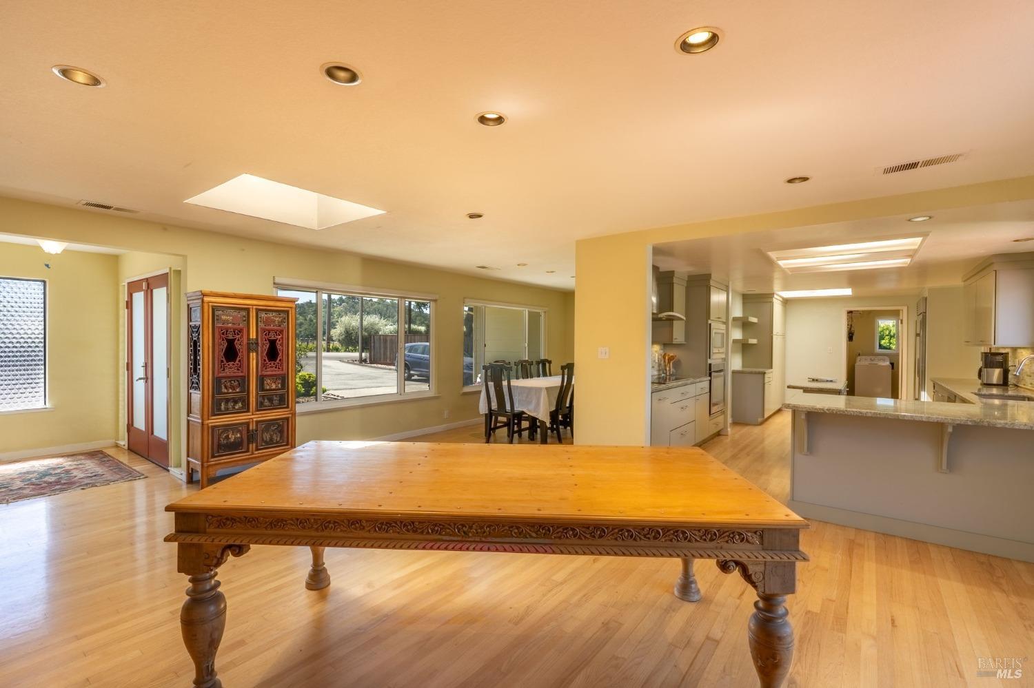 1550 Yountville Cross Road Napa, CA 94558 - Photo 16 of 45 a living room with dining table and wooden floor