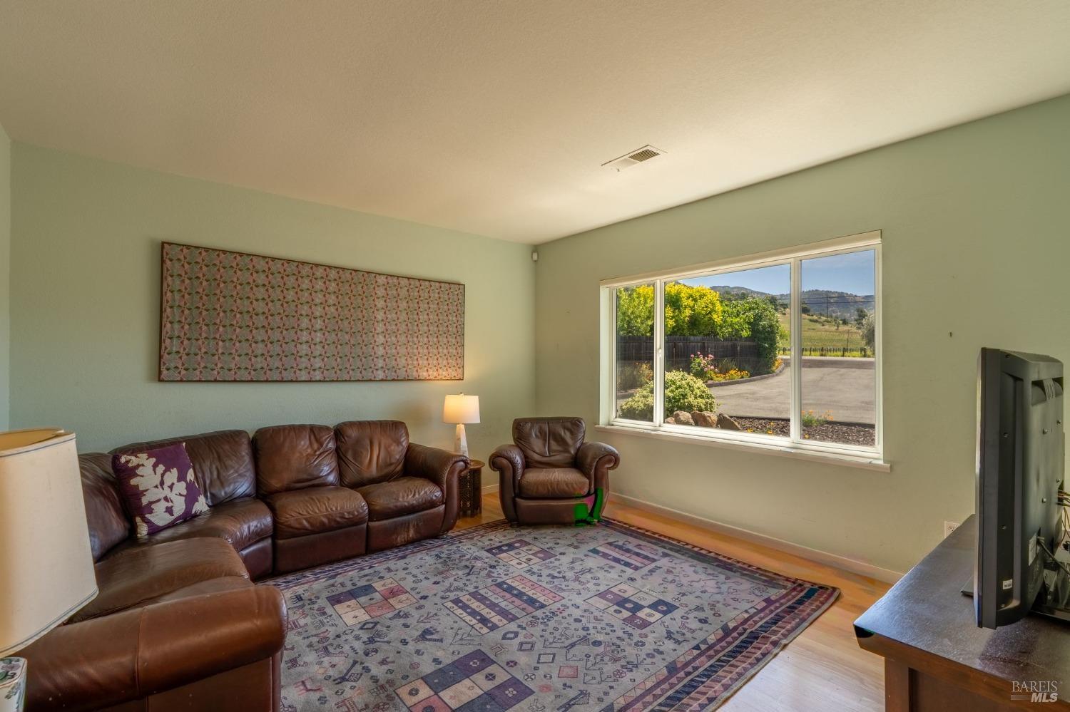 1550 Yountville Cross Road Napa, CA 94558 - Photo 17 of 45 a living room with furniture rug and a flat screen tv