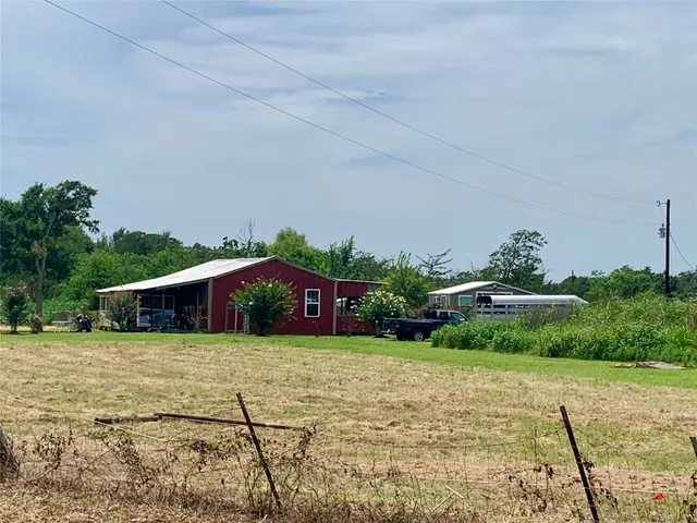 a view of a big yard with plants and large trees