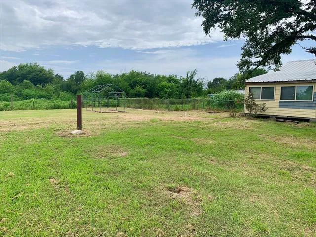 a view of a green field with wooden fence