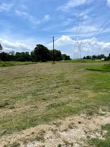 a yard with lots of green space and house in back