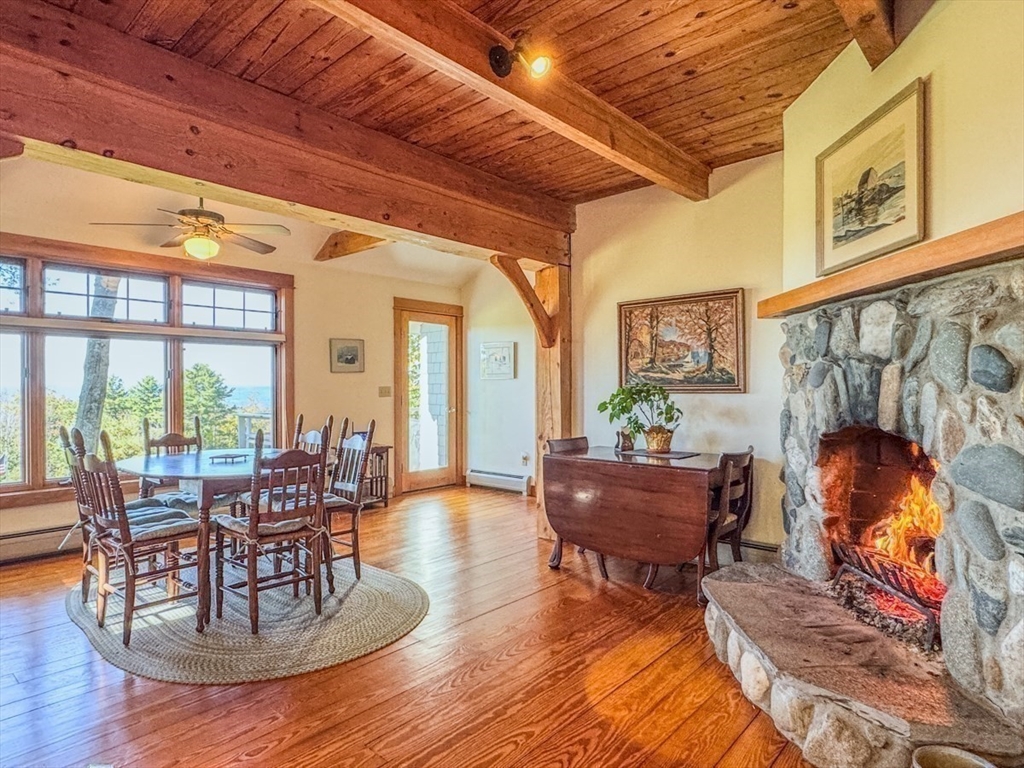 261 Old Wendell Road Northfield, MA 01360 - Photo 11 of 42 a living room with furniture a fireplace and a dining table with wooden floor