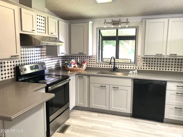 a kitchen with stainless steel appliances a sink stove and cabinets