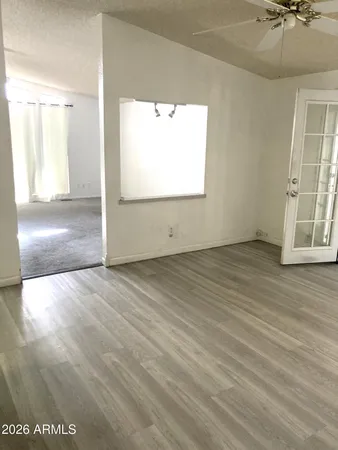 an empty room with wooden floor and windows