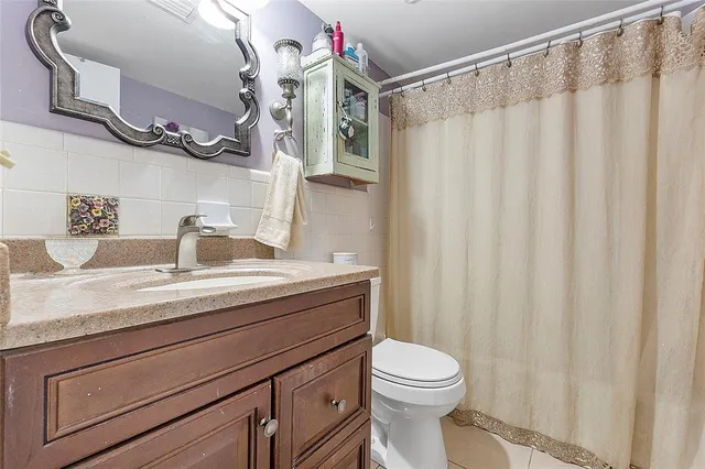 a bathroom with a granite countertop sink a toilet and a mirror