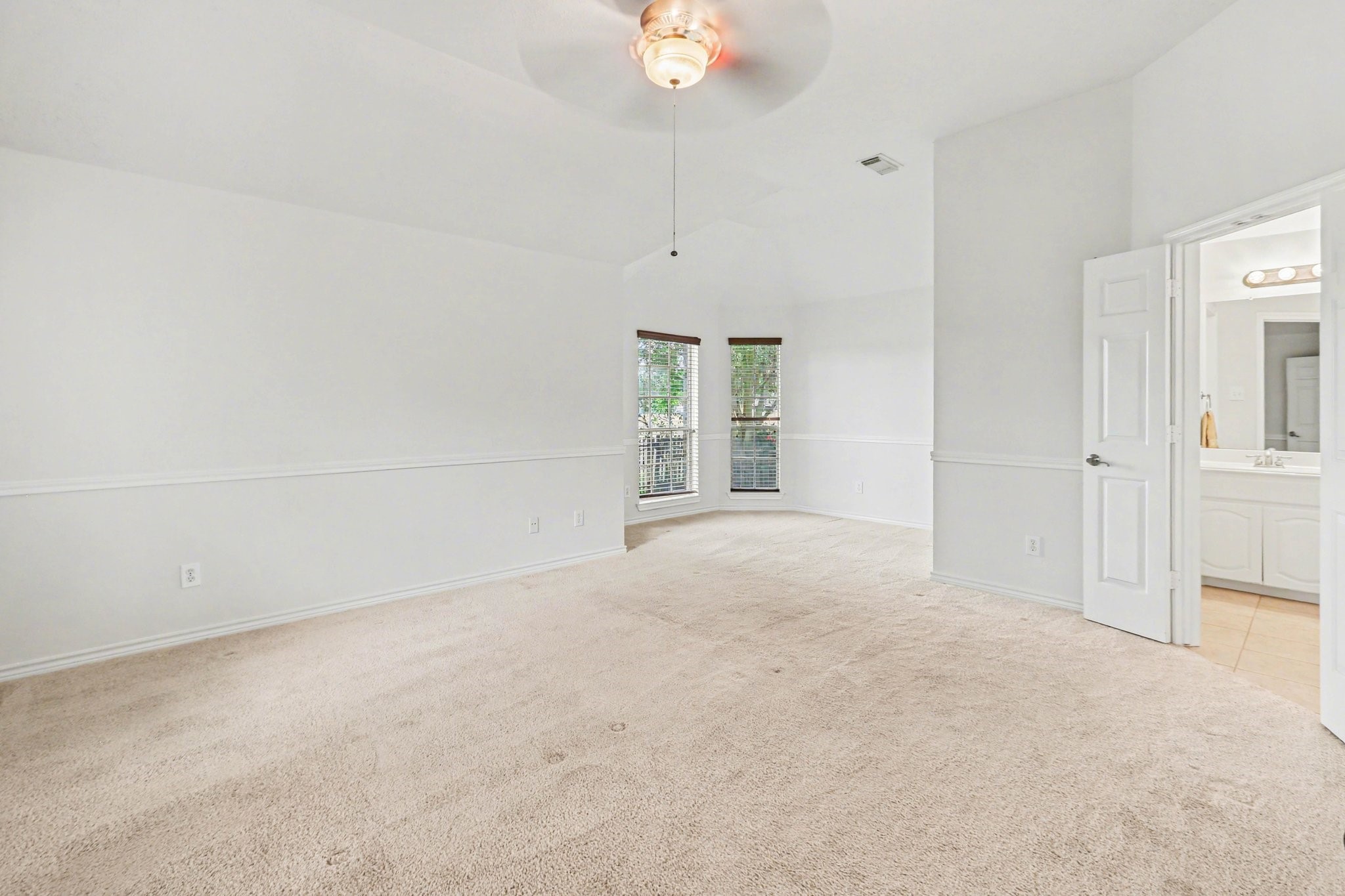 16434 Redcrest Drive Houston, TX 77095 - Photo 22 of 44 Spacious primary bedroom with high ceiling, a ceiling fan and sitting area off to the side. This could be perfect for a workout area, second office or even a crib! Plus, an ensuite bathroom. Ample natural light from windows.