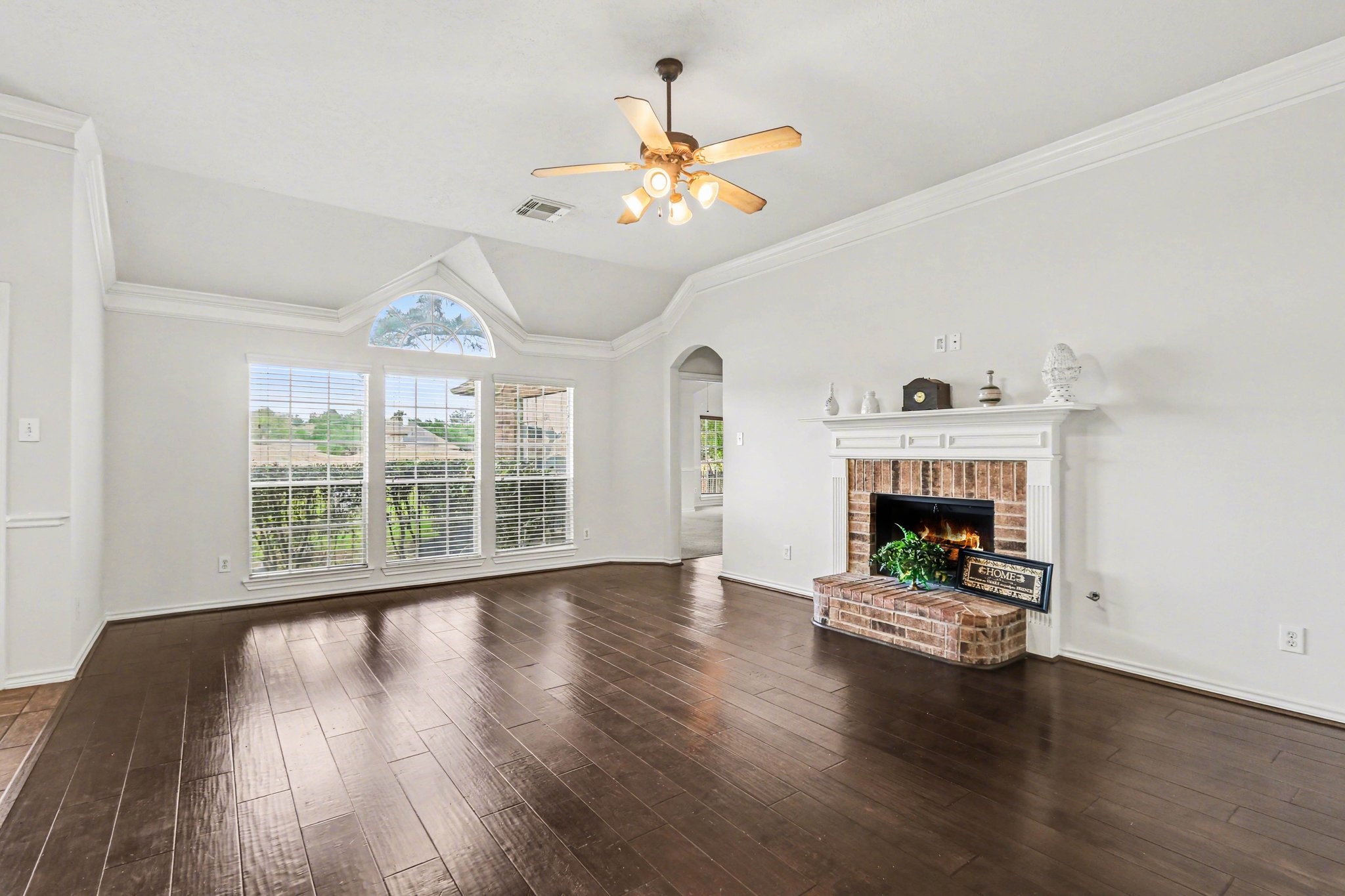16434 Redcrest Drive Houston, TX 77095 - Photo 4 of 44 This inviting living room features a high ceiling with a fan, and large windows that provide ample natural light. The open layout connects seamlessly to the kitchen area, enhancing the spacious feel.