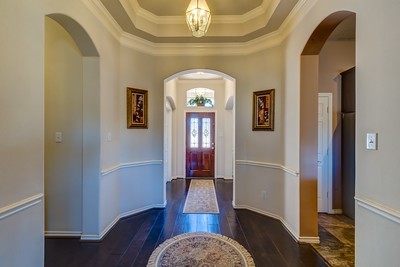 16434 Redcrest Drive Houston, TX 77095 - Photo 6 of 44 Inviting entryway with elegant archways, hardwood floors, and a central light fixture. Features decorative wall moldings and tasteful artwork, creating a warm and welcoming first impression.