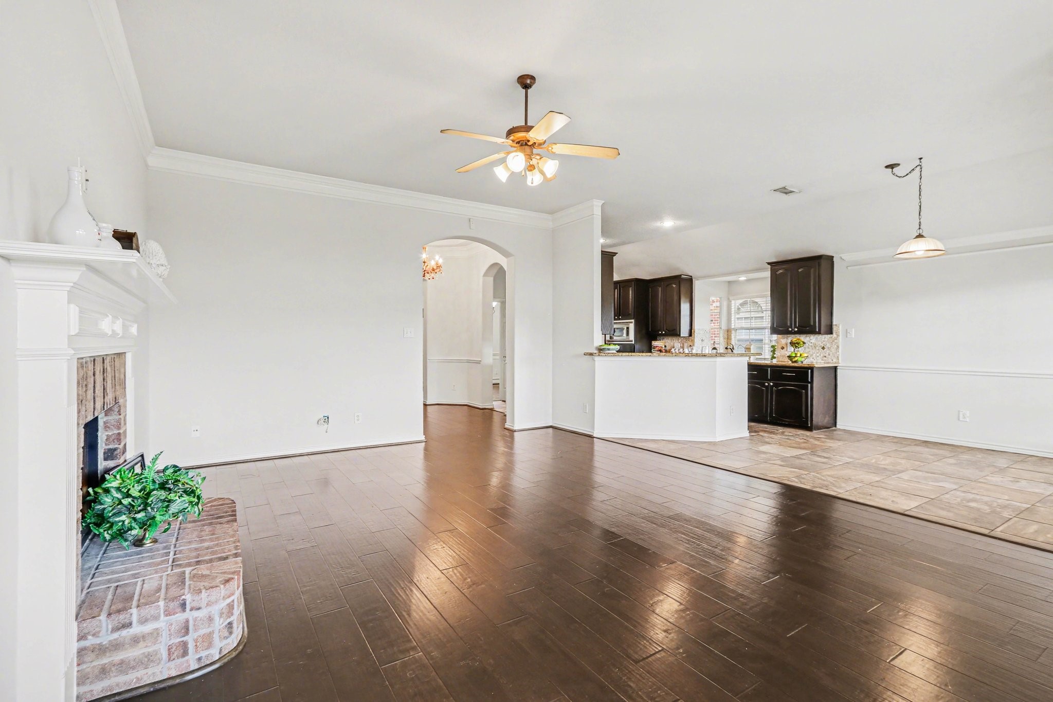 16434 Redcrest Drive Houston, TX 77095 - Photo 10 of 44 This inviting living room features a high ceiling with a fan, and large windows that provide ample natural light. The open layout connects seamlessly to the kitchen area, enhancing the spacious feel.