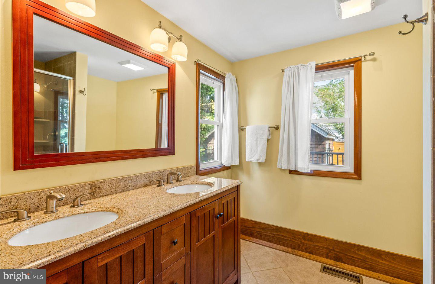 223 Rodney Street Rehoboth Beach, DE 19971 - Photo 25 of 59 a bathroom with a granite countertop sink and a mirror