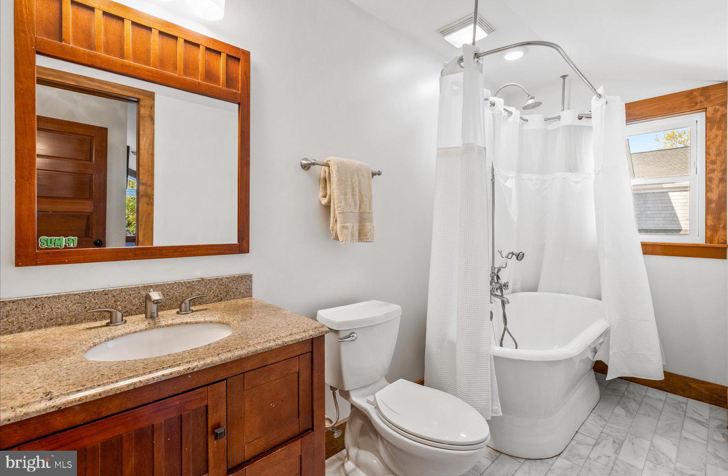 223 Rodney Street Rehoboth Beach, DE 19971 - Photo 26 of 59 a bathroom with a granite countertop toilet sink and mirror