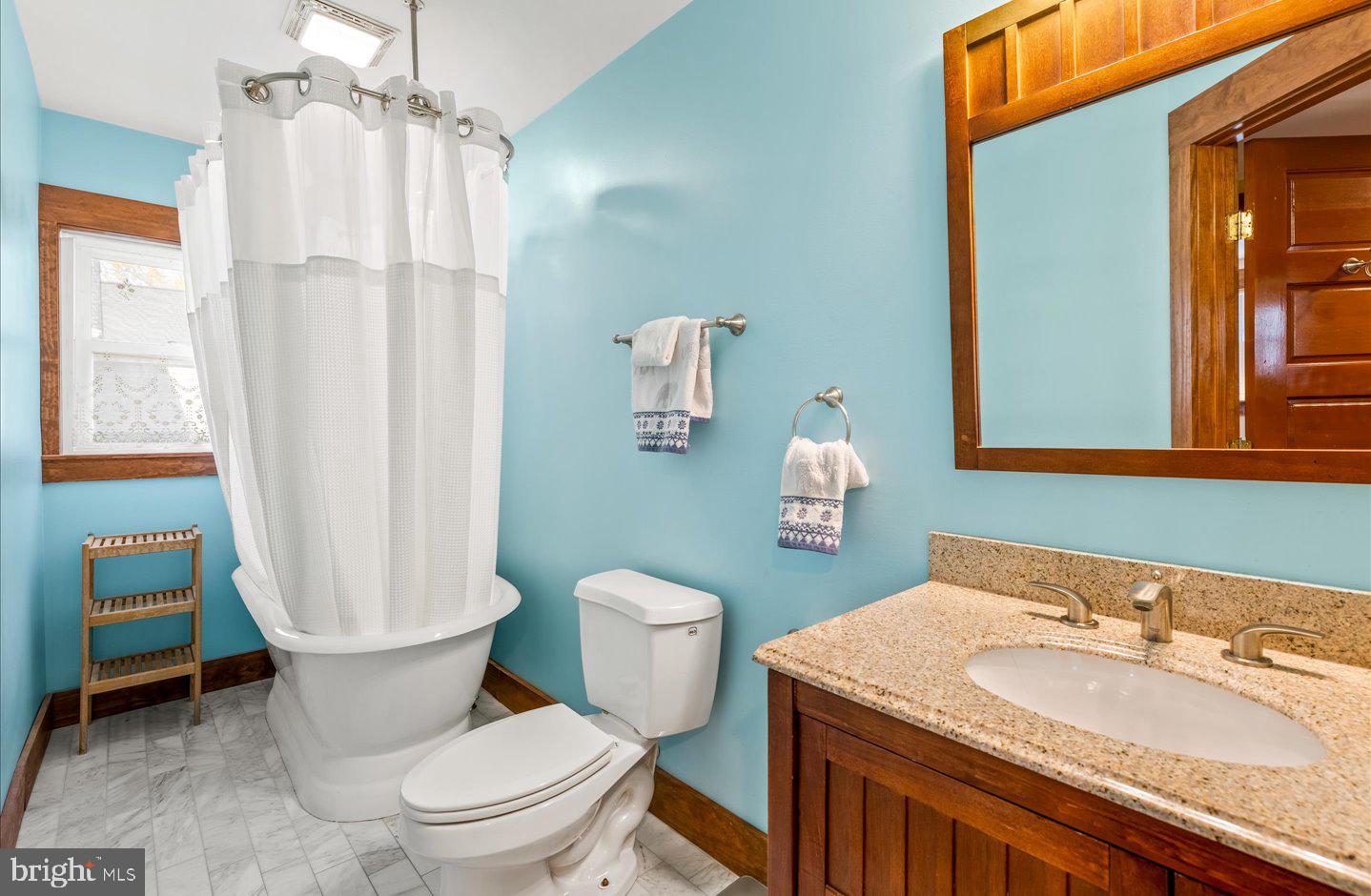 223 Rodney Street Rehoboth Beach, DE 19971 - Photo 39 of 59 a bathroom with a granite countertop toilet a sink and a mirror