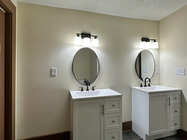 a bathroom with a double vanity sink and a mirror