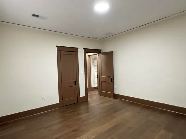 an empty room with wooden floor and closet