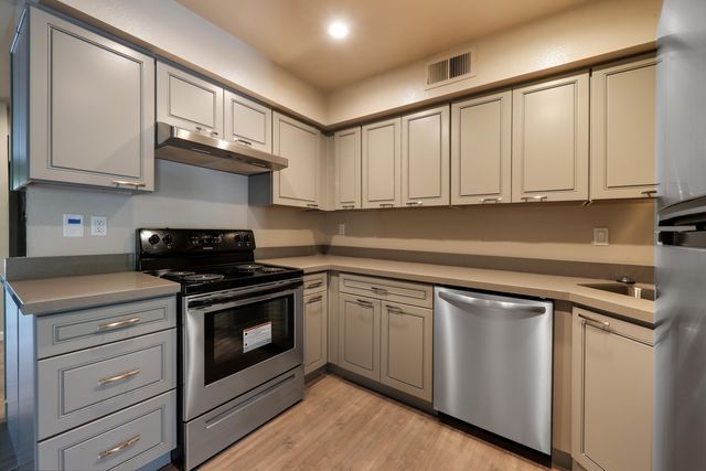 a kitchen with stainless steel appliances granite countertop a stove a sink and cabinets