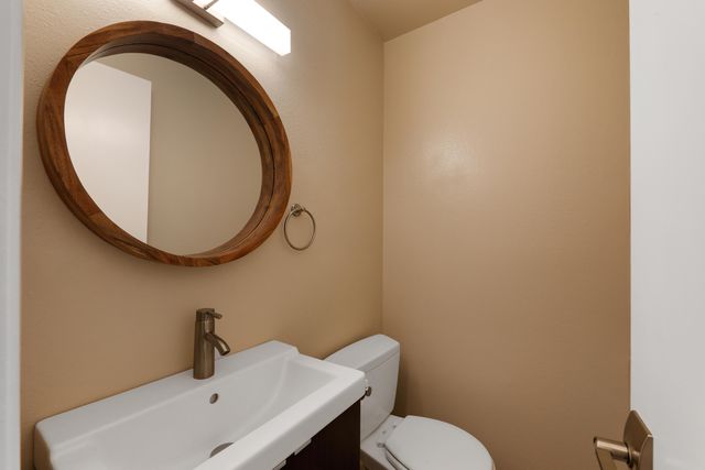 a bathroom with a sink mirror and toilet