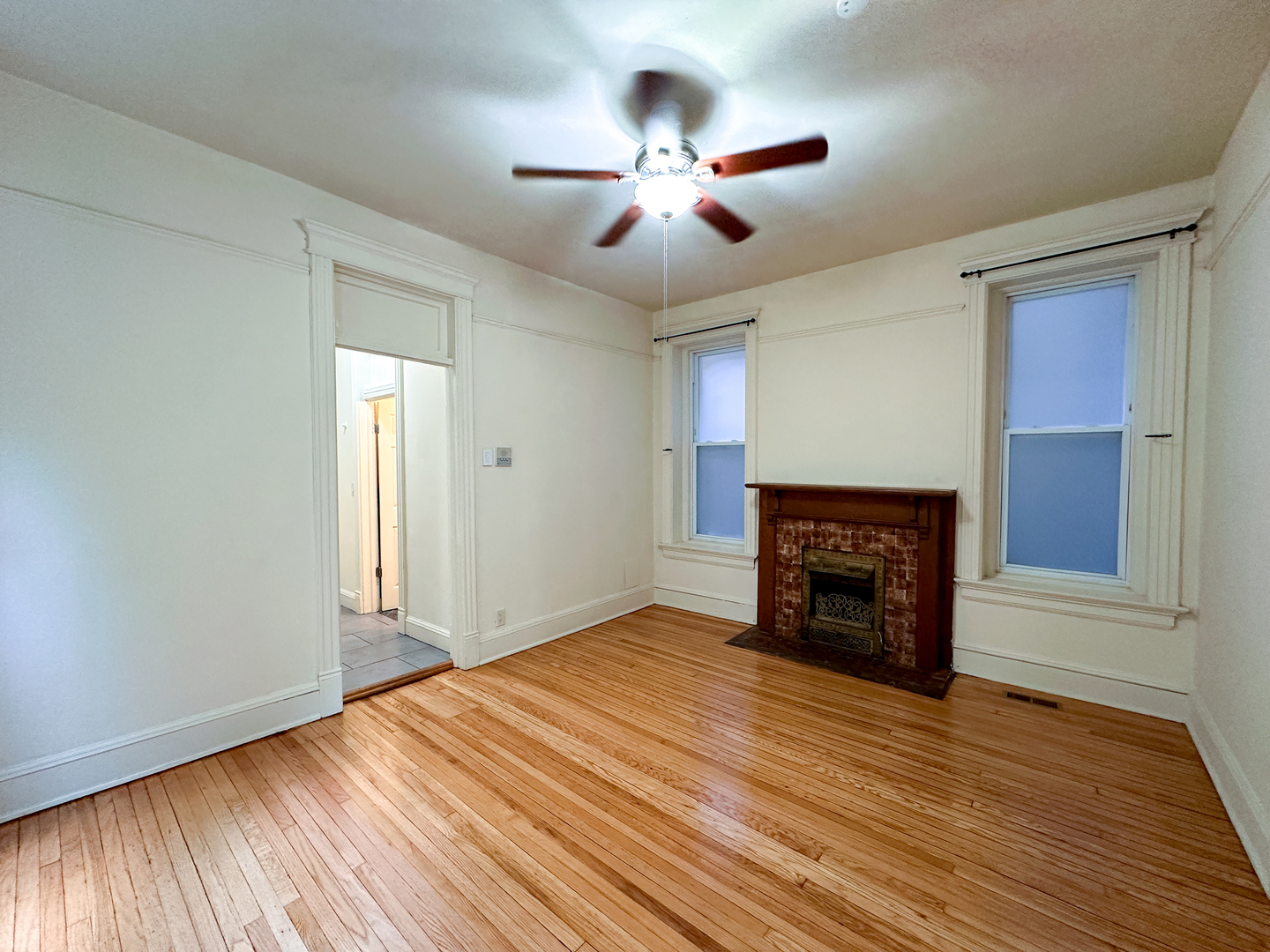 2126 North Sheffield Avenue, Unit 1 Chicago, IL 60614 - Photo 22 of 24 a view of an empty room with wooden floor fireplace and a window