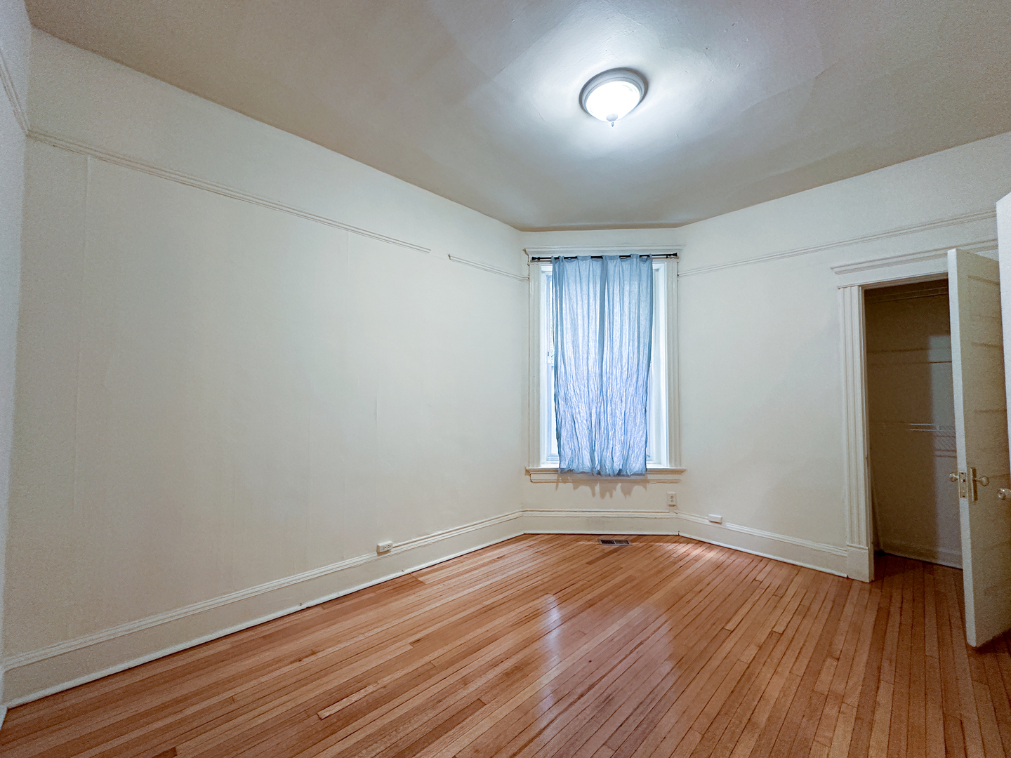 2126 North Sheffield Avenue, Unit 1 Chicago, IL 60614 - Photo 4 of 24 an empty room with wooden floor and windows