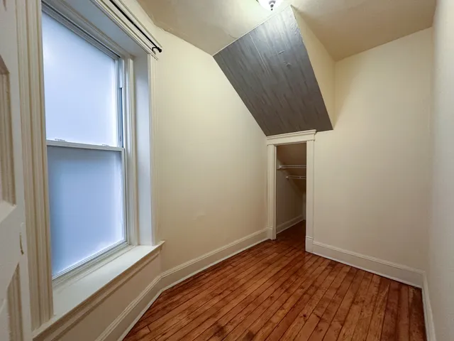a view of a hallway with wooden floor and entryway