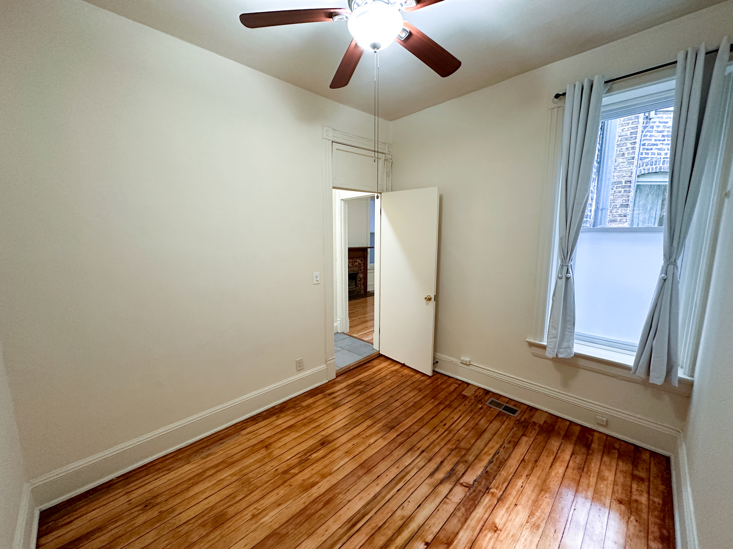 2126 North Sheffield Avenue, Unit 1 Chicago, IL 60614 - Photo 10 of 24 a view of an empty room with wooden floor and a window