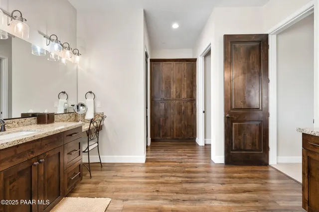 a bathroom with a granite countertop sink a toilet a mirror and bathtub