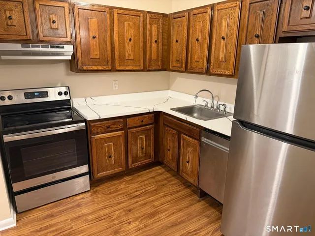 a kitchen with stainless steel appliances granite countertop a refrigerator sink and stove