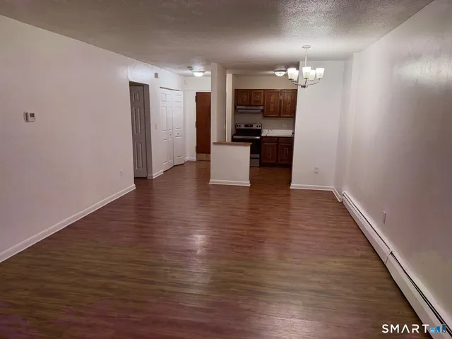 a view of empty room with wooden floor