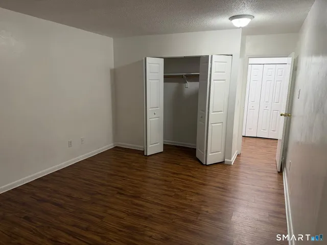 an empty room with wooden floor and closet