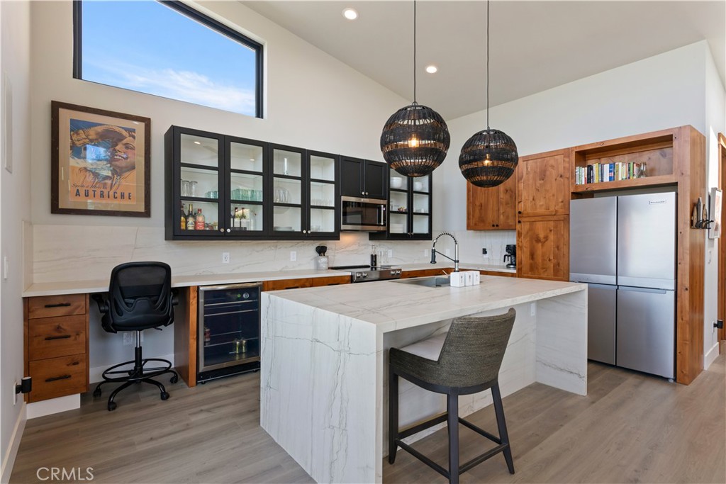 12630 Lakeshore Drive Clearlake, CA 95422 - Photo 17 of 73 a kitchen with stainless steel appliances kitchen island a table chairs in it and wooden floors