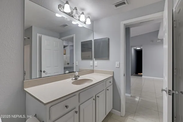 a bathroom with a sink vanity and a mirror