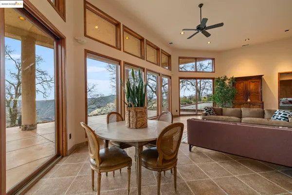 a dining room with furniture a chandelier and wooden floor